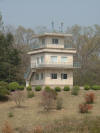 North Korean Guard Tower.  Guards are inside looking at us, taking pictures and filming us as well...